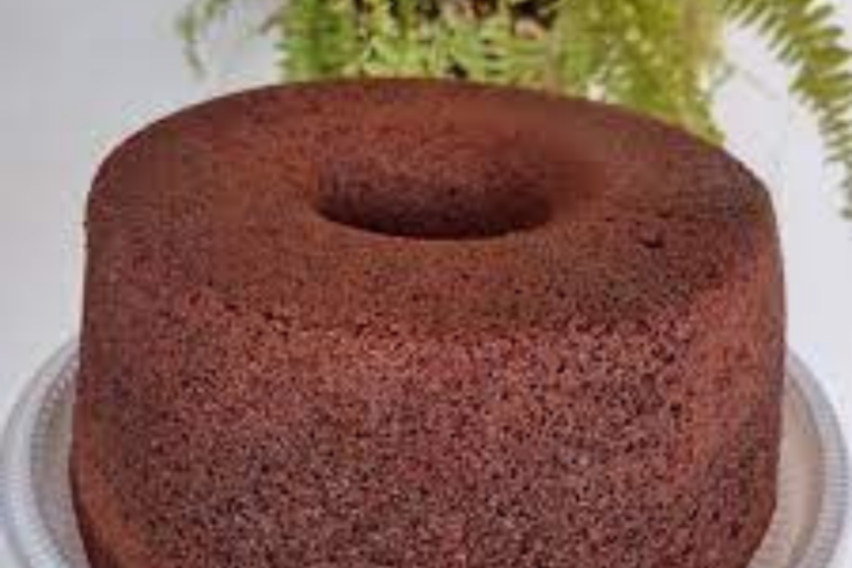 Bolo de chocolate fofinho e úmido, recém-saído do forno, com cobertura brilhante escorrendo pelas laterais.